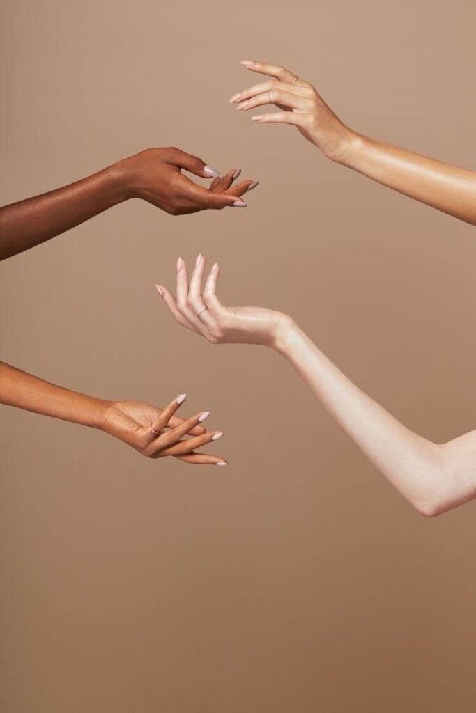 Close-up of women’s hands interlinked in a gesture of unity and mutual support. This image represents the spirit of collective action, solidarity, and the strength of female connection — a core value of The Collective Rising’s mission to amplify women’s voices and foster community.